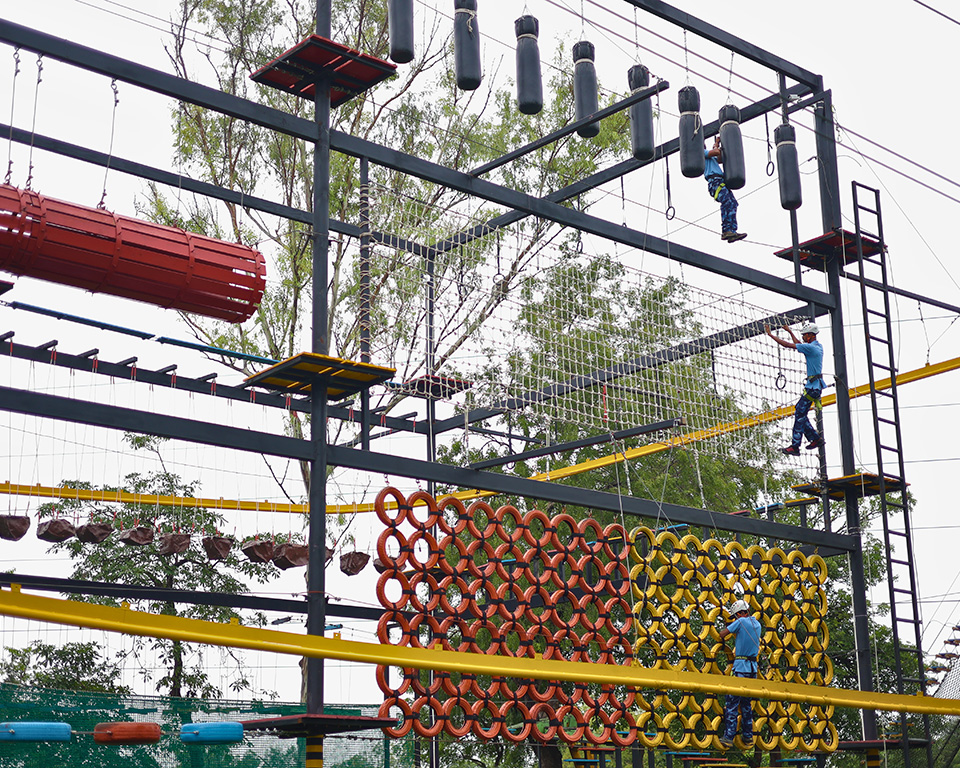 Guests using three-floor rope course at adventure park near Ahmedabad at Roadies Rostel ARC Resort