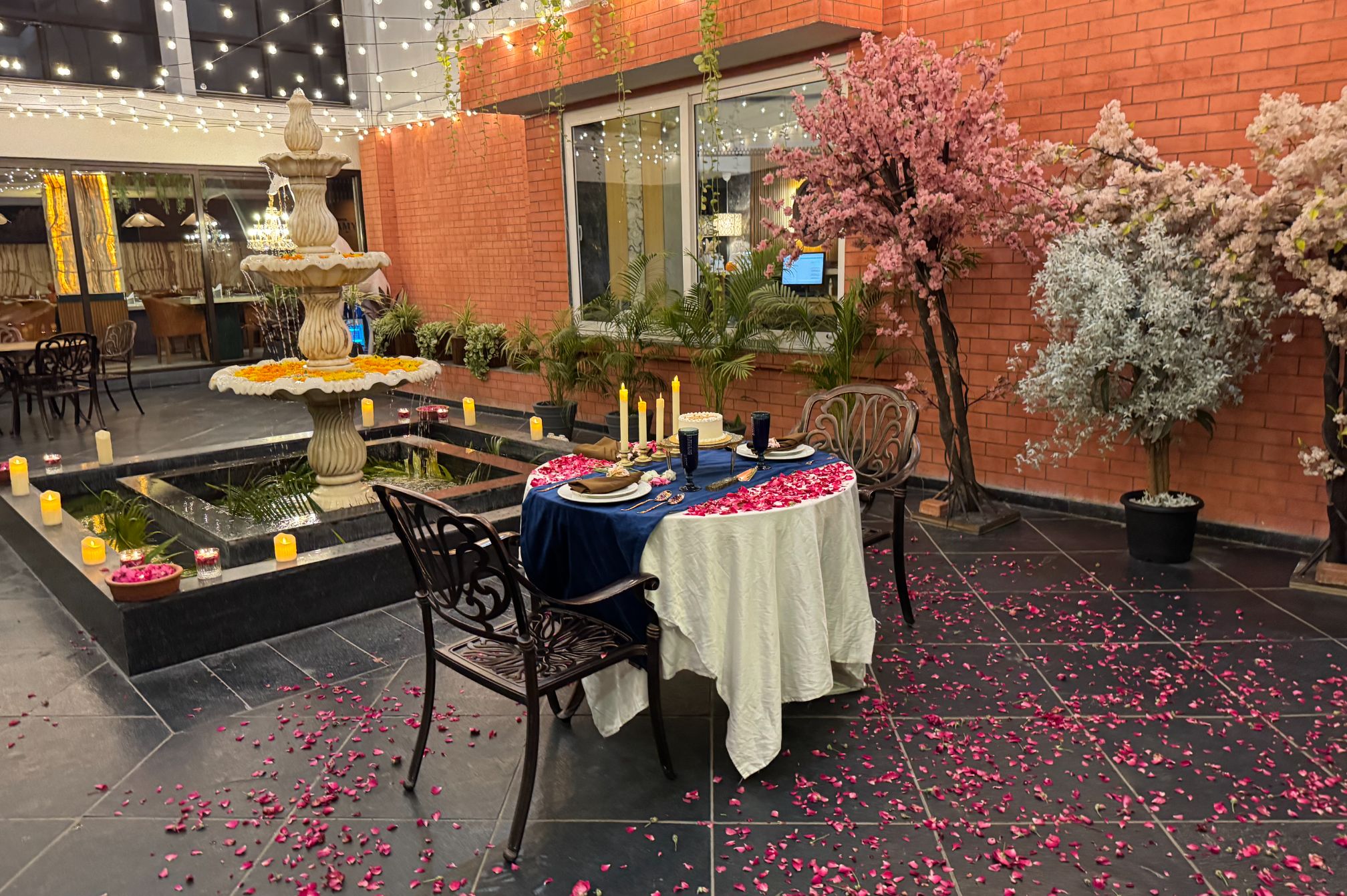 Fountain-side celebration setup at Roadies Rostel ARC Resort with floral decor and warm lighting