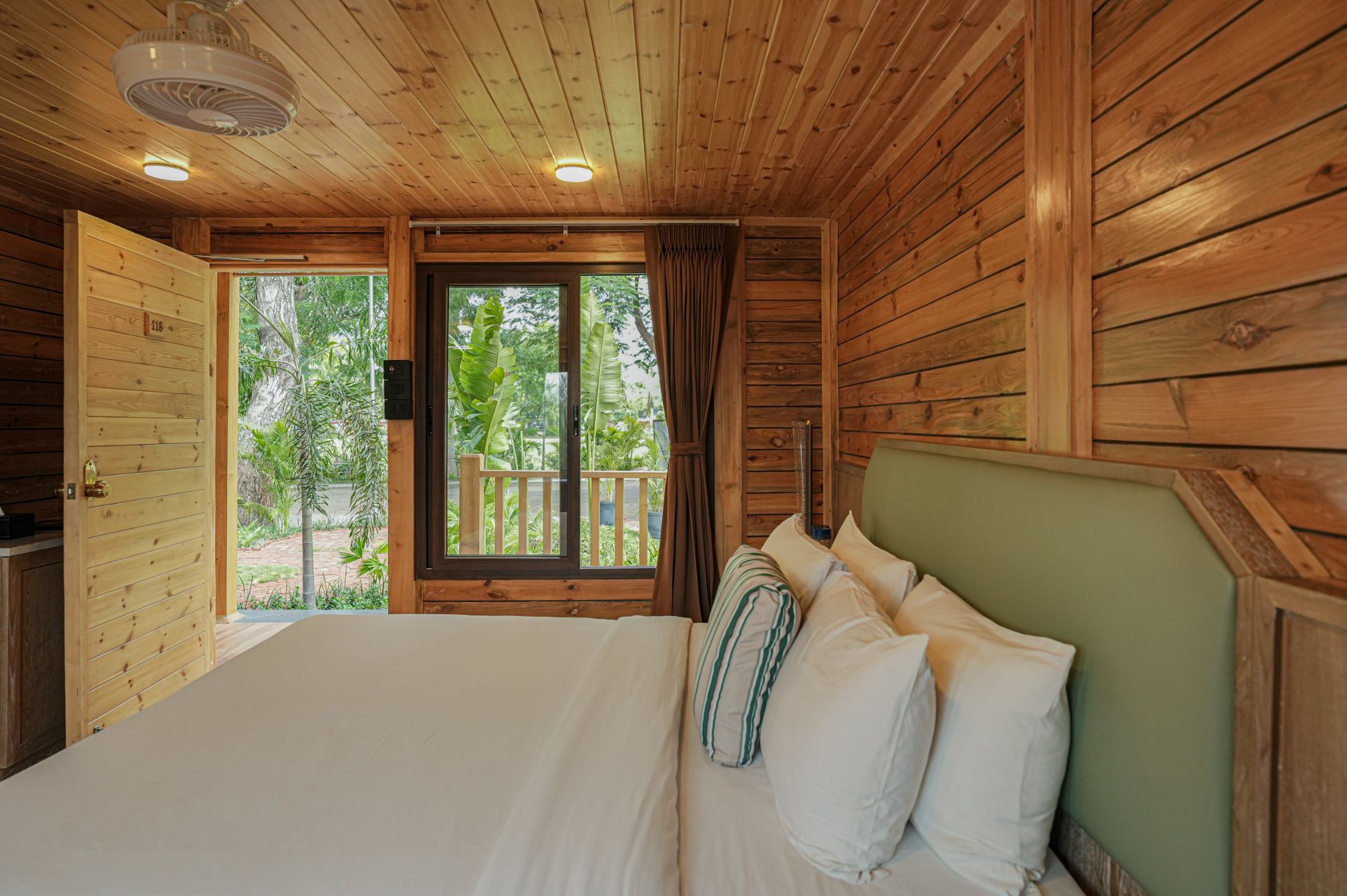 Bright and cozy wooden cottage bedroom setup for a luxurious stay at Roadies Rostel ARC Resort.