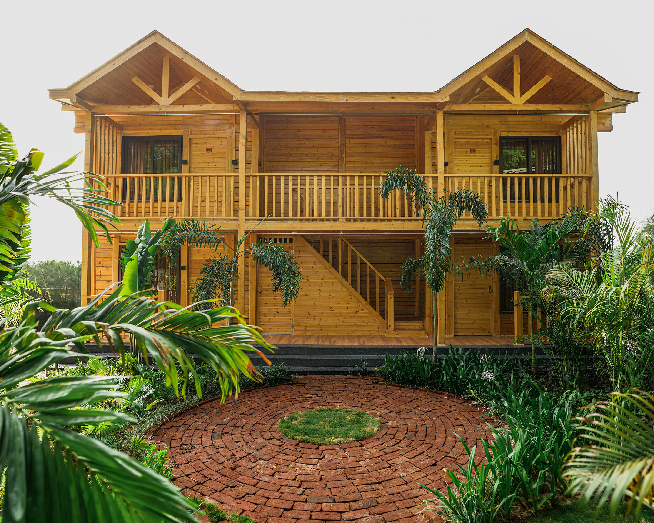 Main landing image showing the front view of a beautifully crafted wooden cottage at Roadies Rostel ARC Resort, Ahmedabad.