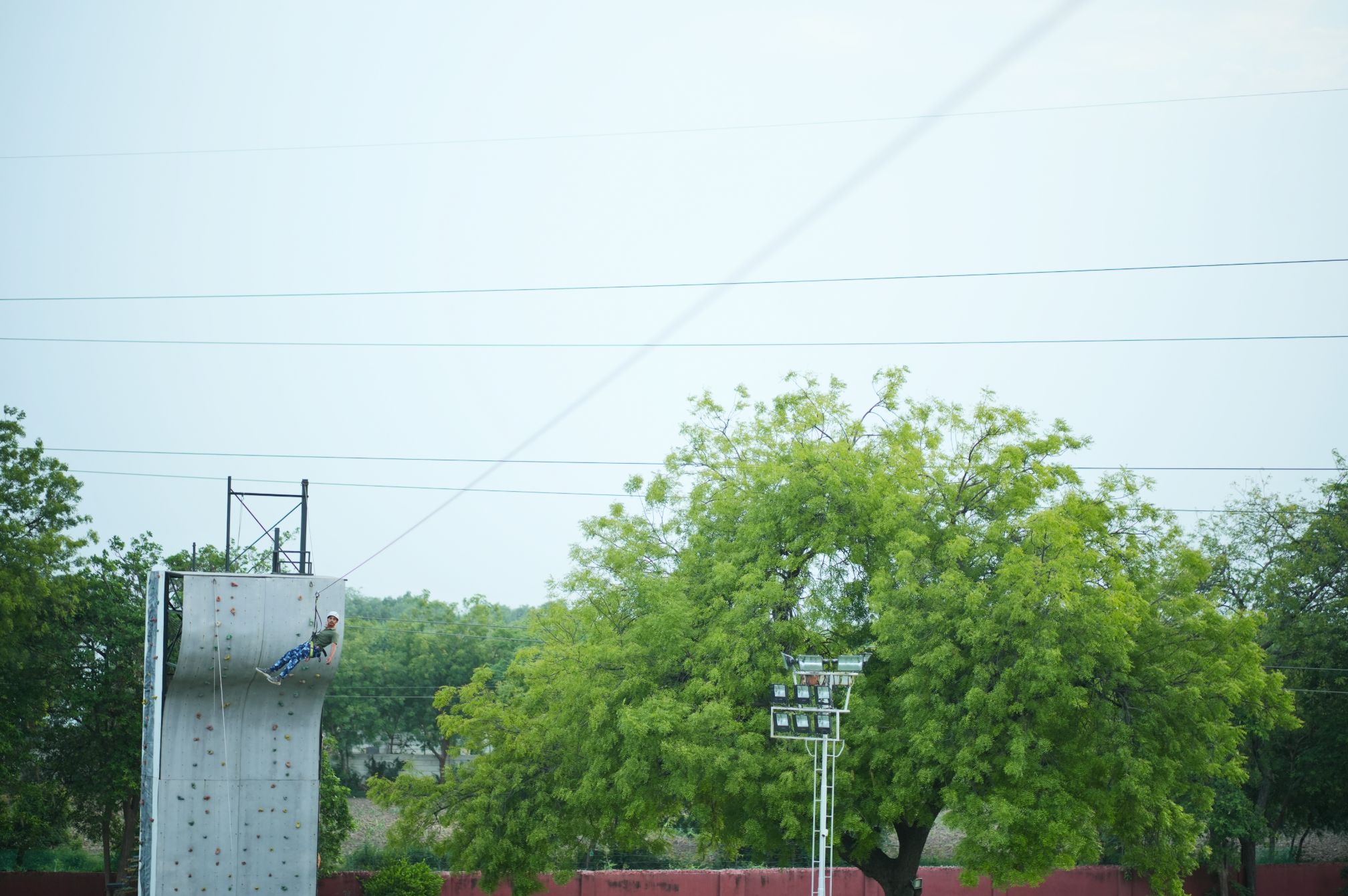 Guest enjoying rappelling down the climbing wall at Ahmedabad adventure resort