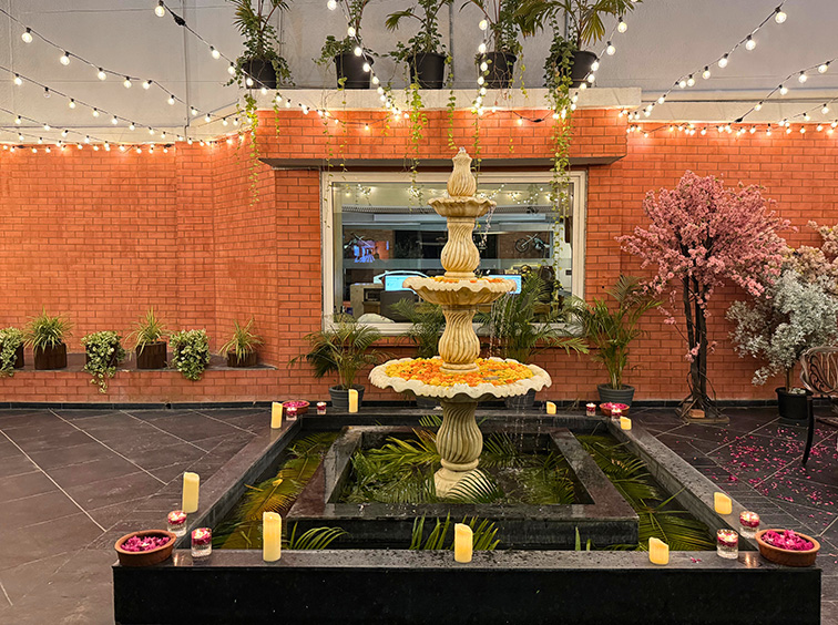 Close-up of flower and candle decor at The Neer, creating a dreamy celebration ambiance by the fountain at a luxury resort near Ahmedabad.