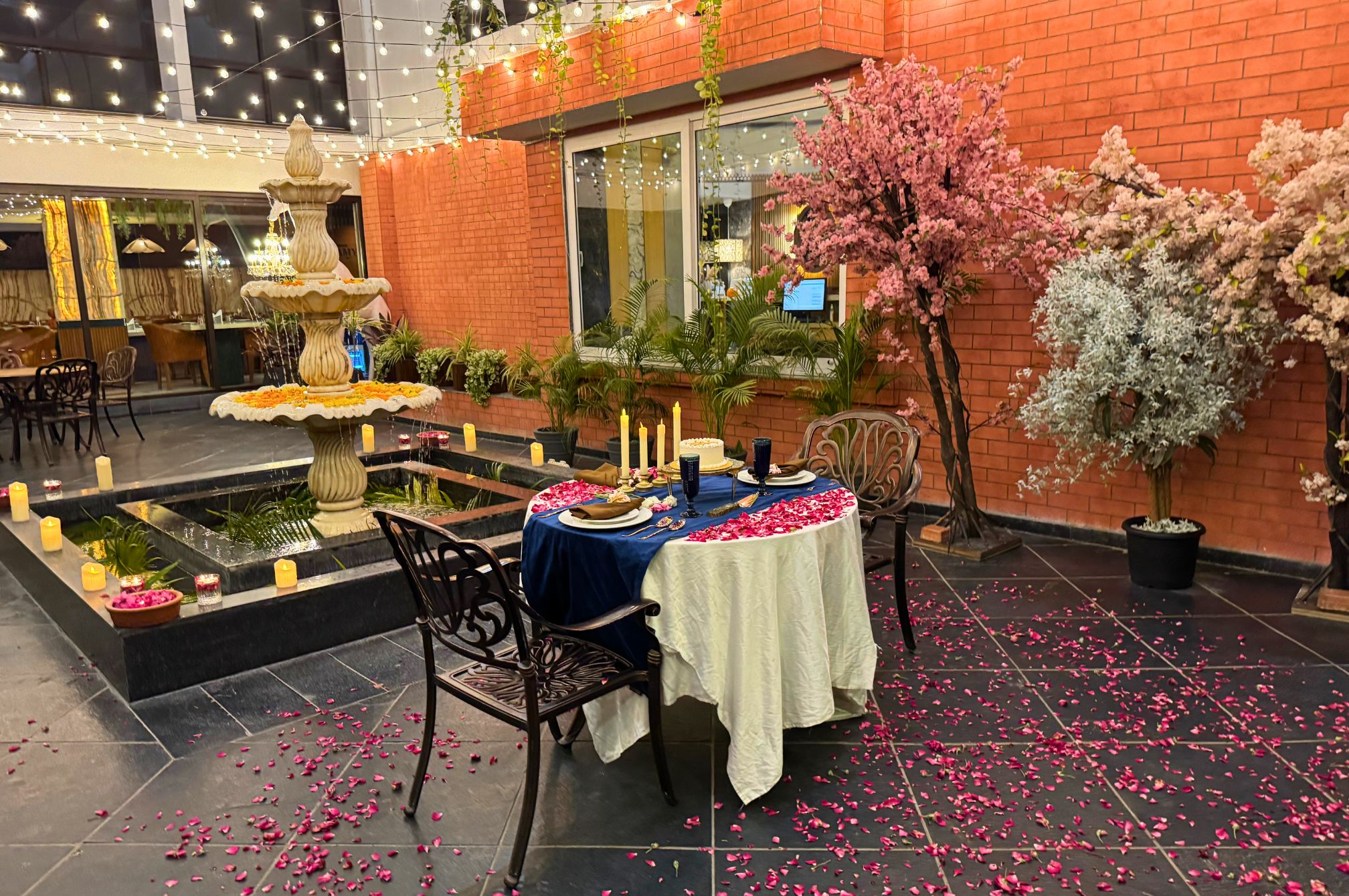 Table setup beside the fountain at Roadies Rostel ARC Resort, perfect for outdoor celebrations near Ahmedabad.