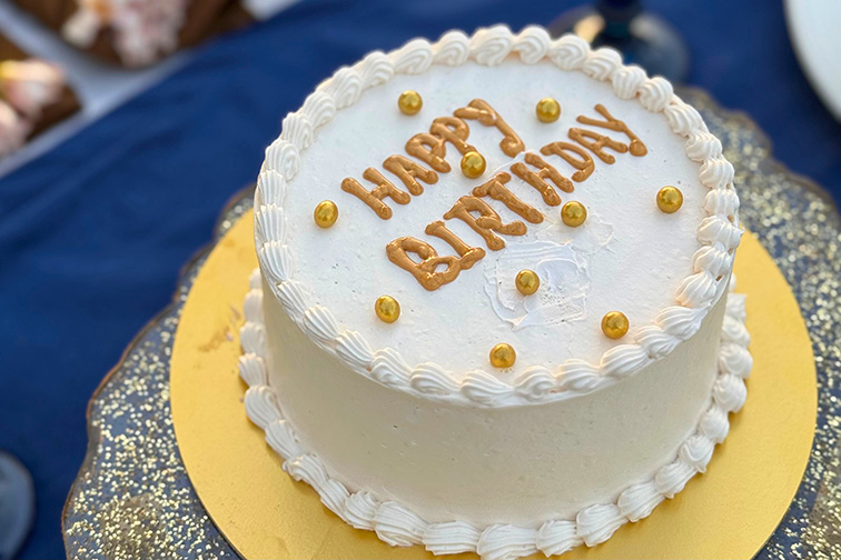 Celebration cake placed in a garden setting at Roadies Rostel ARC Resort, perfect for sunset events and special moments.