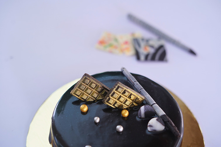 Close-up of a rich chocolate cake served during a celebration at Roadies Rostel ARC Resort near Ahmedabad.