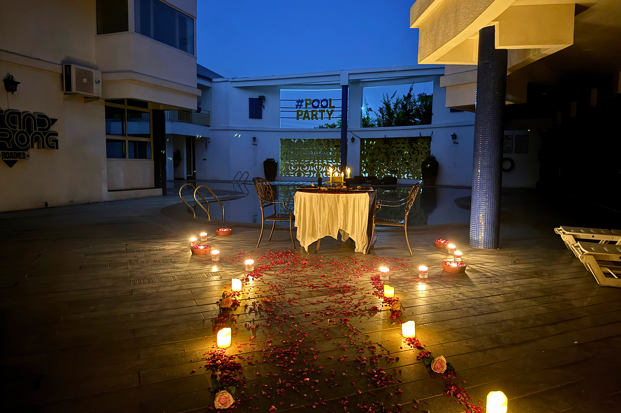 Evening poolside celebration illuminated with warm lights at one of the best resorts near Ahmedabad for special occasions.