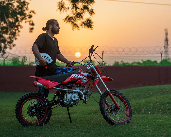 Man posing with dirt bike at Roadies Rostel ARC, a one day picnic resort near Ahmedabad with thrilling adventure rides