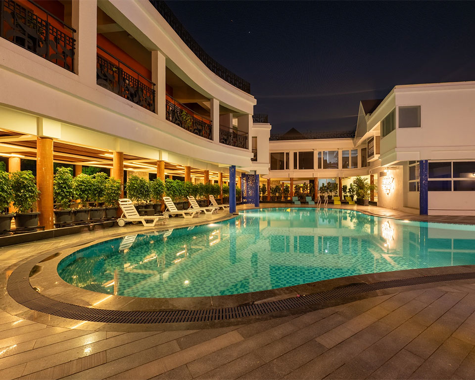 Swimming pool at dusk with ambient lighting, perfect for romantic evenings at Roadies Rostel ARC