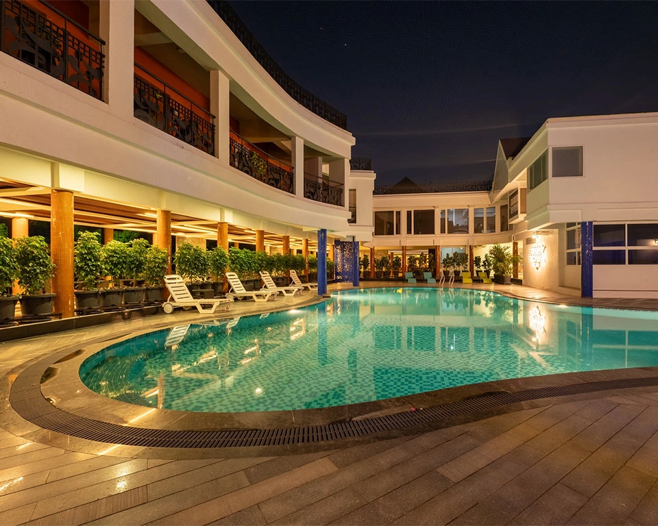 Swimming pool at dusk with ambient lighting, perfect for romantic evenings at Roadies Rostel ARC