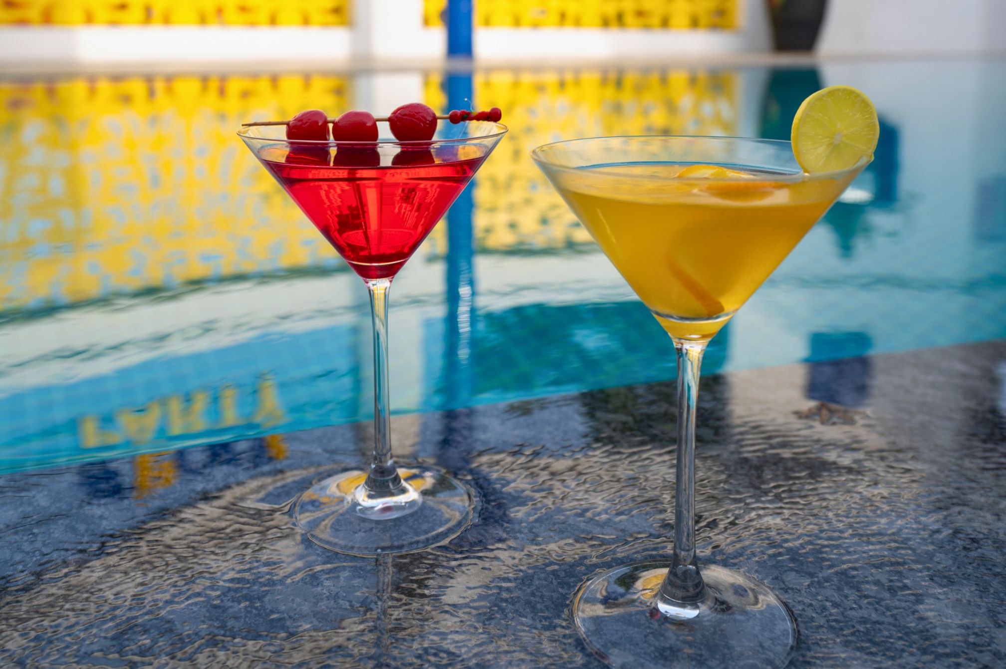 Hibiscus and citrus mocktail garnished with lime, mint, and flowers served on a wooden table