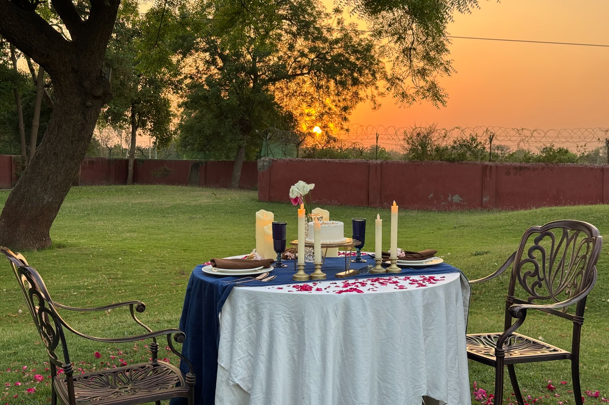 Close-up view of private candlelight dinner setup at sunset in the garden