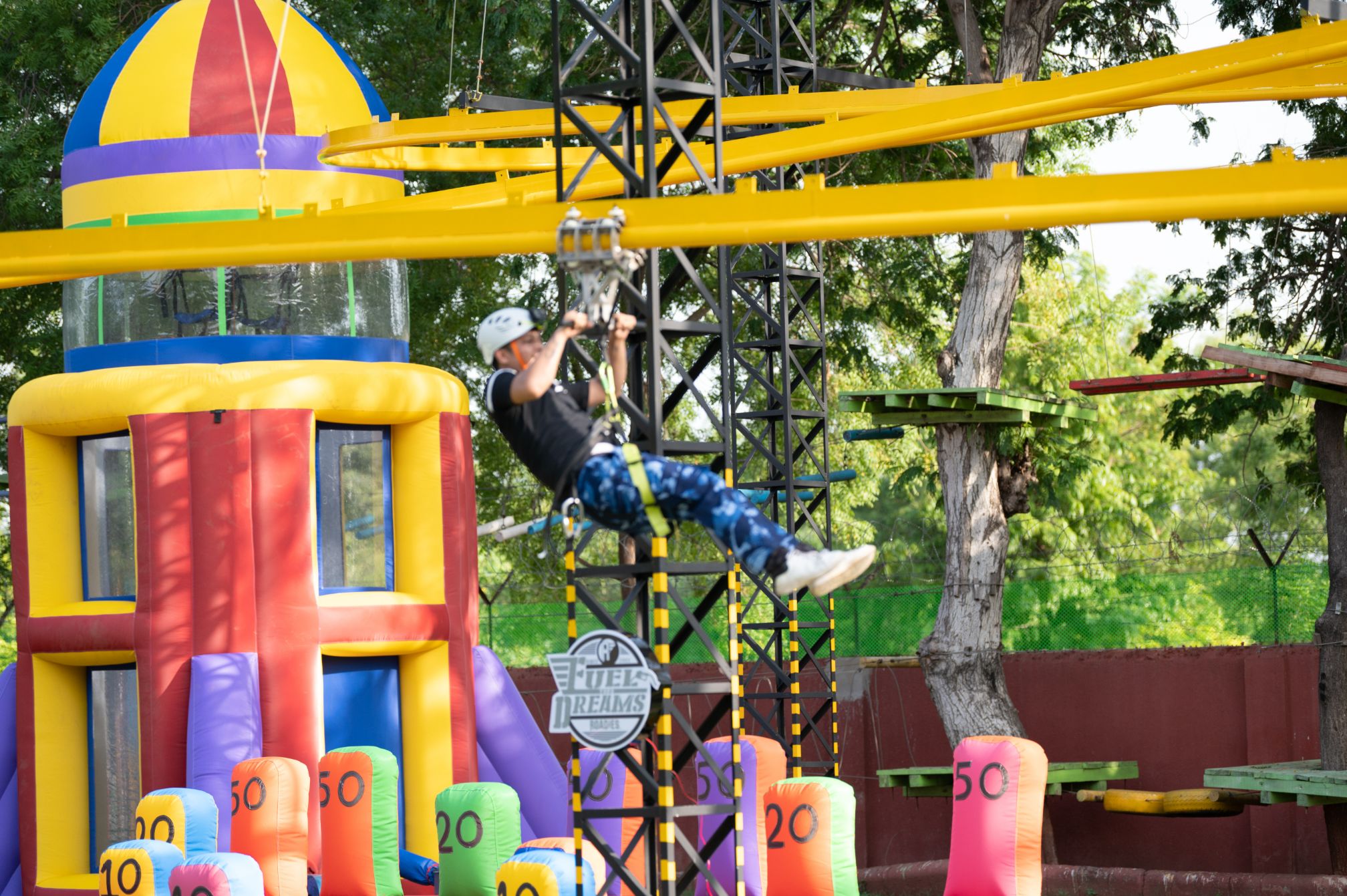 Guest enjoying a zipline ride over inflatable target game at Roadies Rostel ARC Resort