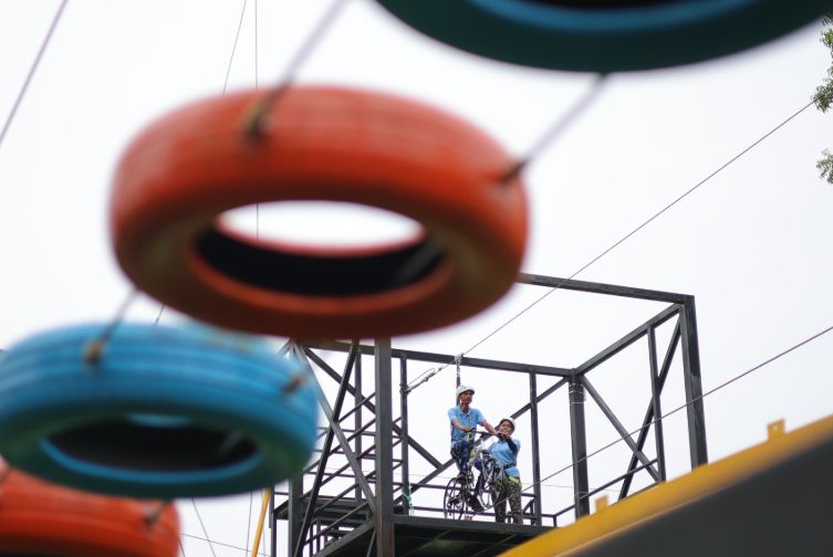 Guest preparing to ride the sky cycle at Roadies Rostel ARC Resort adventure park near Ahmedabad