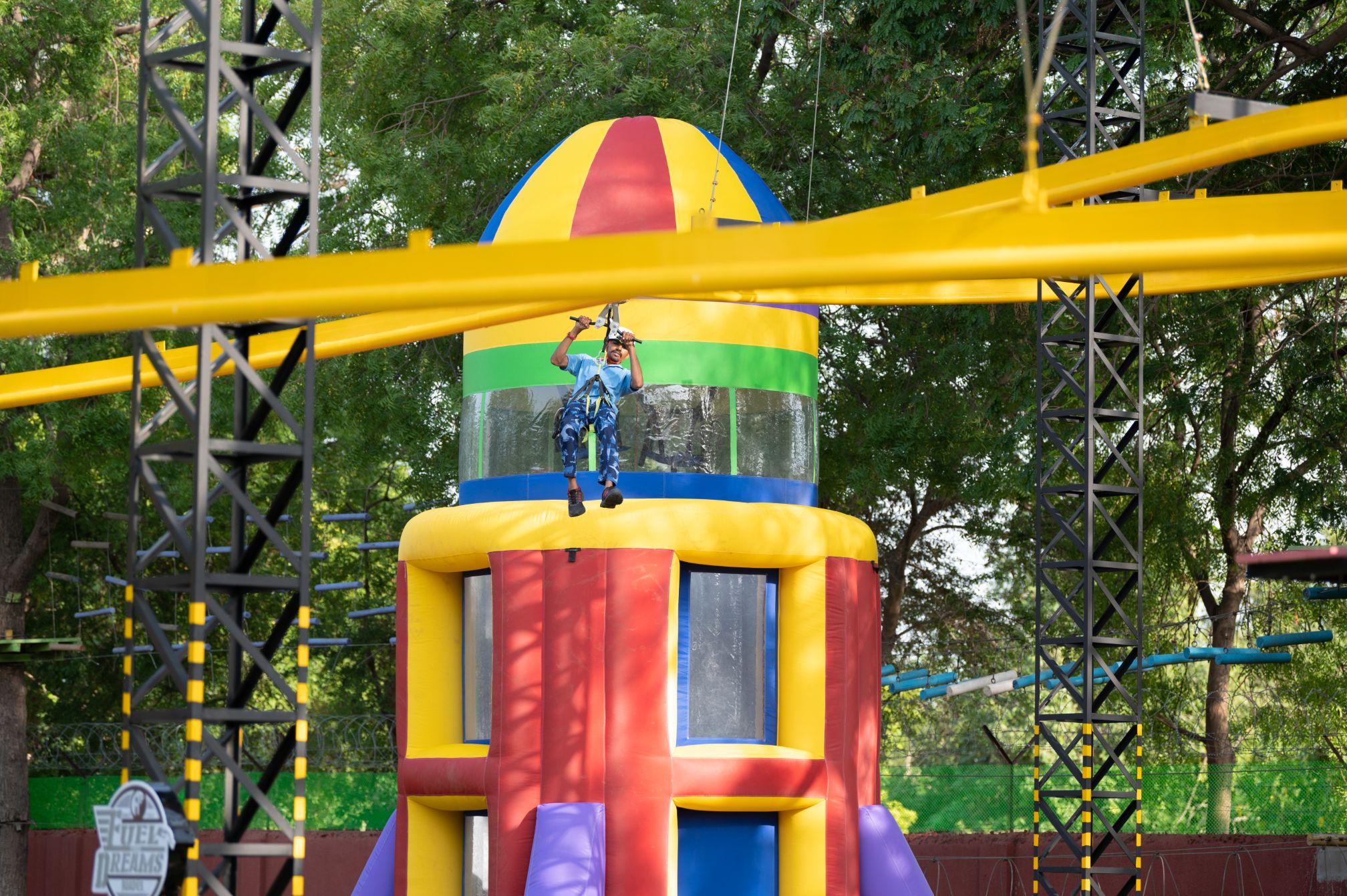 Guest enjoying the rollercoaster zipline ride at Roadies Rostel ARC Resort adventure park surrounded by trees