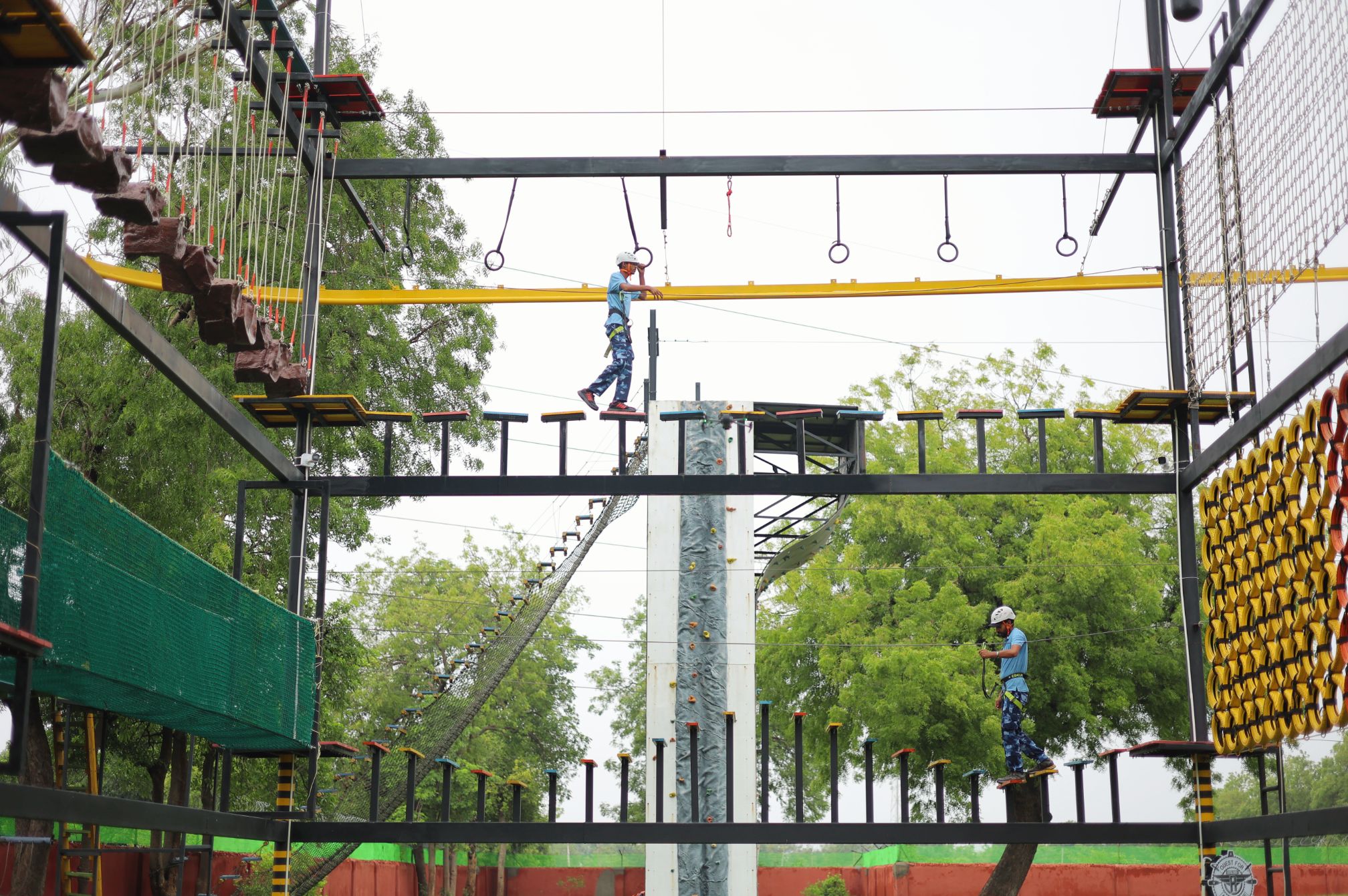 Guests navigating obstacles on multi-level rope course at Roadies Rostel ARC Resort adventure park near Ahmedabad