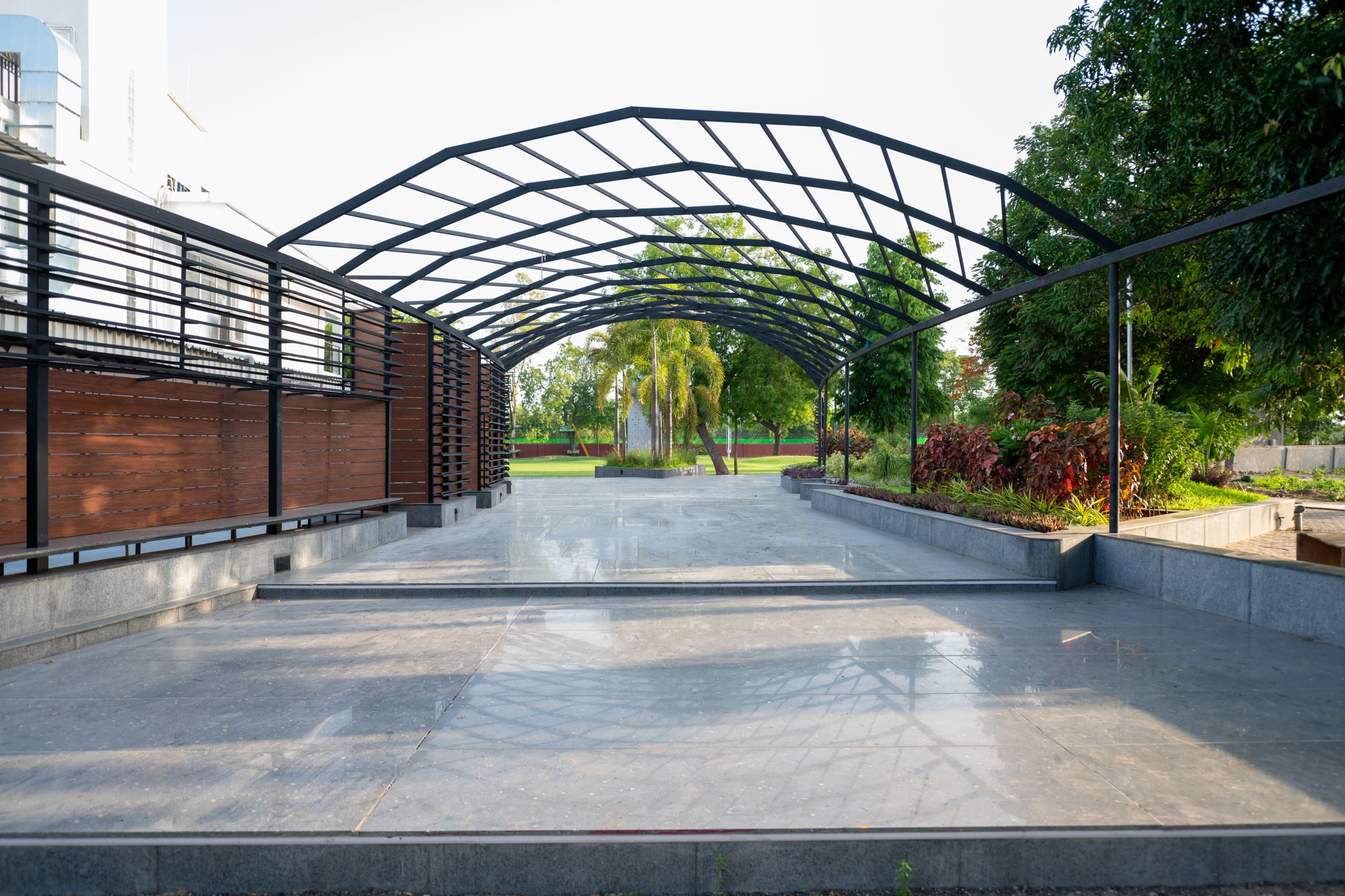 Architectural canopy walkway at Roadies Rostel ARC Resort surrounded by landscaped gardens and greenery