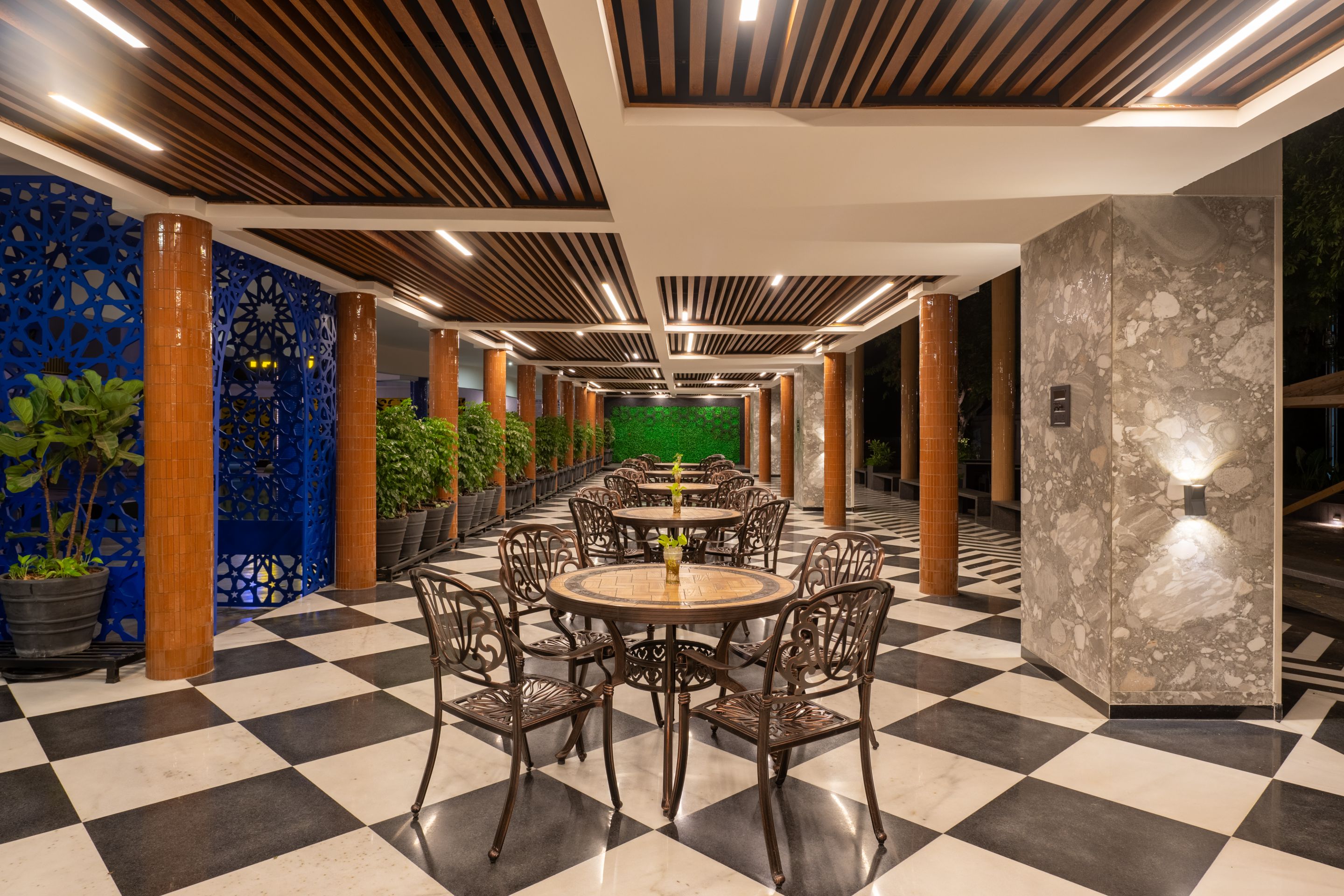 Elegant outdoor dining area with classic seating and green backdrop at Roadies Rostel ARC Resort