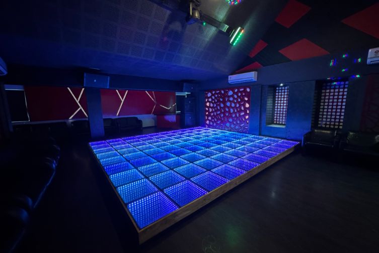 Evening party setup with vibrant lights and dancefloor at Roadies Rostel ARC Resort