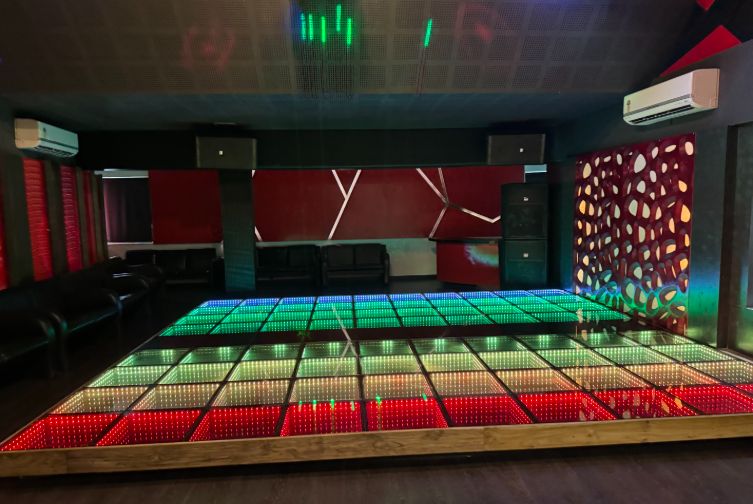 Multicolor lighting on LED discotheque floor with geometric decor at Roadies Rostel ARC Resort