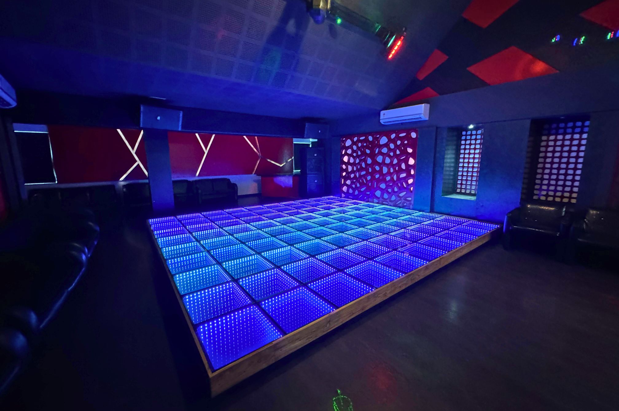 Blue glow LED floor and energetic ambiance for dance parties at Roadies Rostel ARC Resort