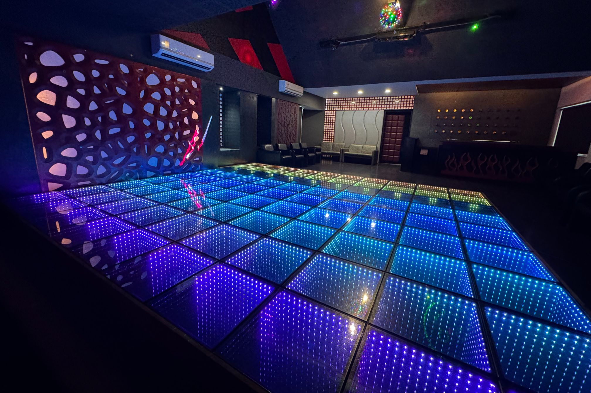 Colorfully lit dance floor with modern ambiance for group parties and DJ nights near Ahmedabad