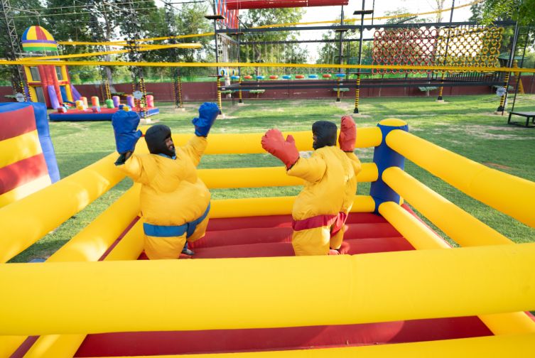 Guests enjoying inflatable sumo wrestling at one day picnic resort near Ahmedabad