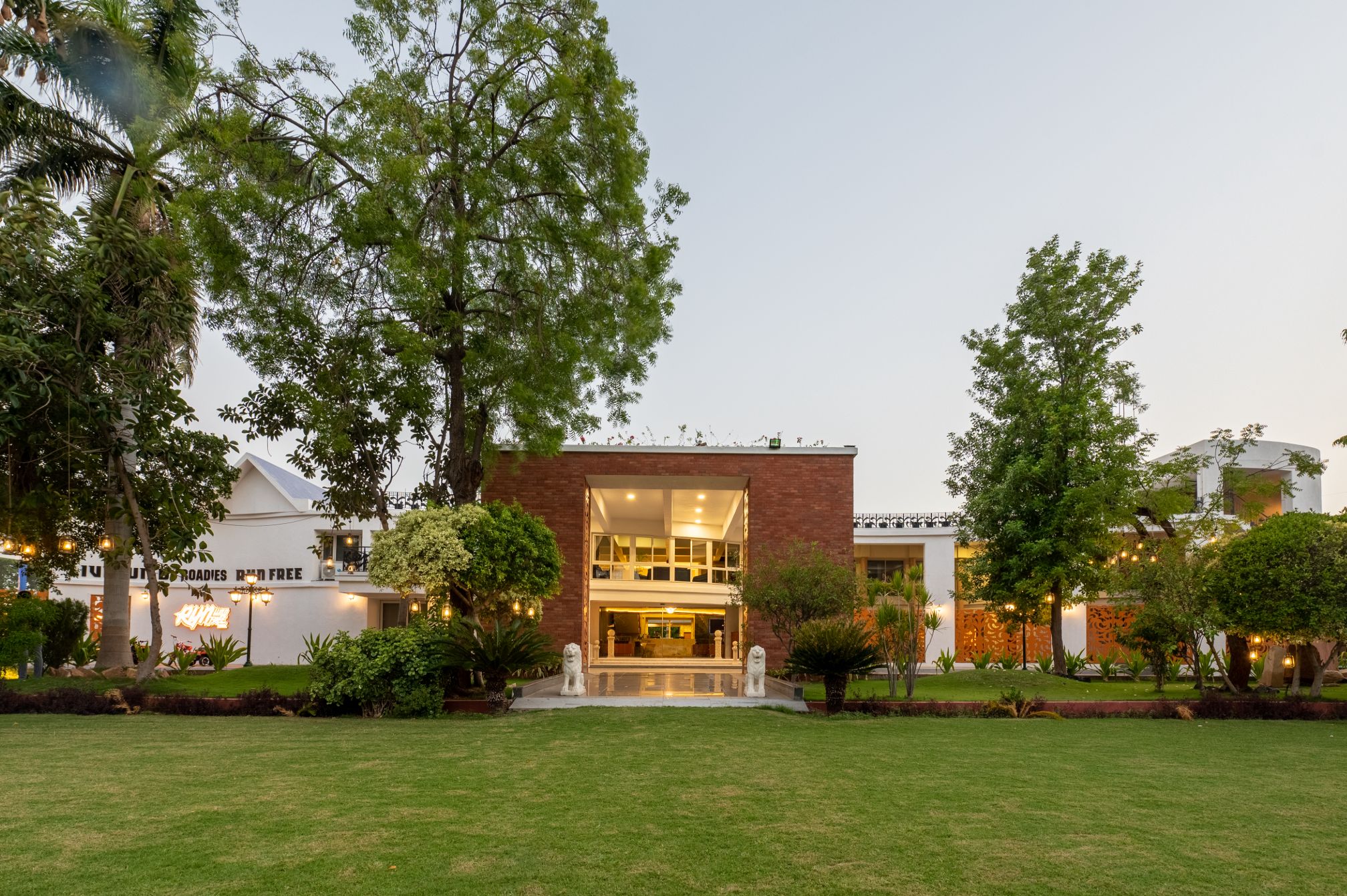 Elegant brick entrance facade of Roadies Rostel ARC Resort captured during golden hour