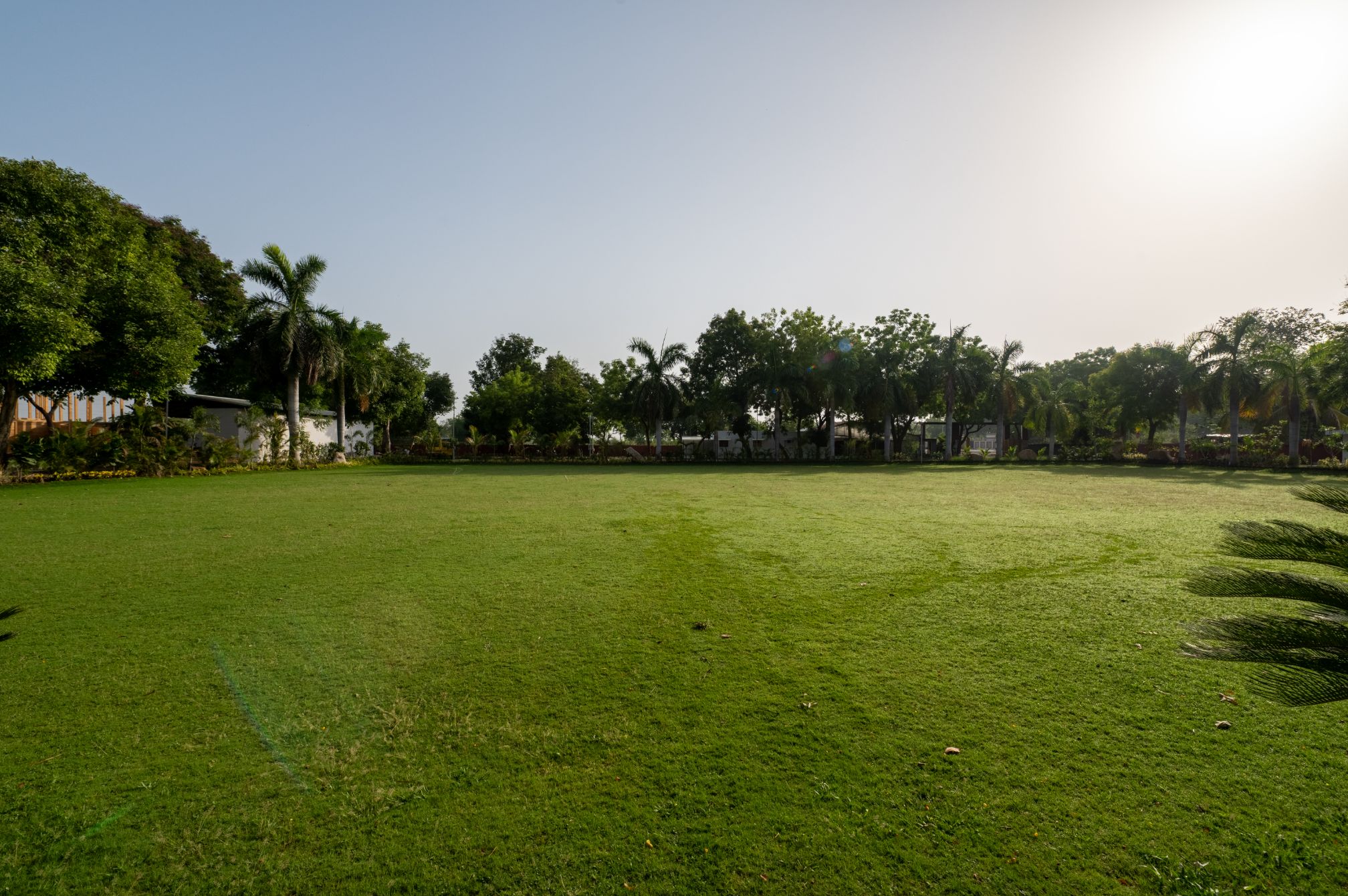 Expansive green lawn at Roadies Rostel Resort, perfect for outdoor events, day picnics, and family gatherings near Ahmedabad.