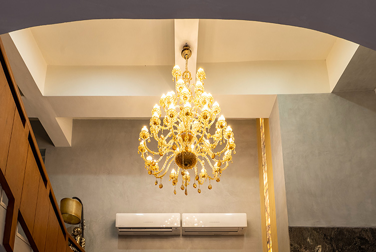 Elegant golden chandelier in a premium celebration space at Roadies Rostel ARC Resort