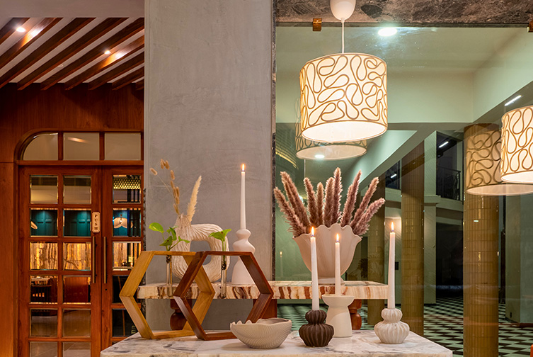 Warm indoor celebration decor with candles and pendant lighting at Roadies Rostel ARC Resort