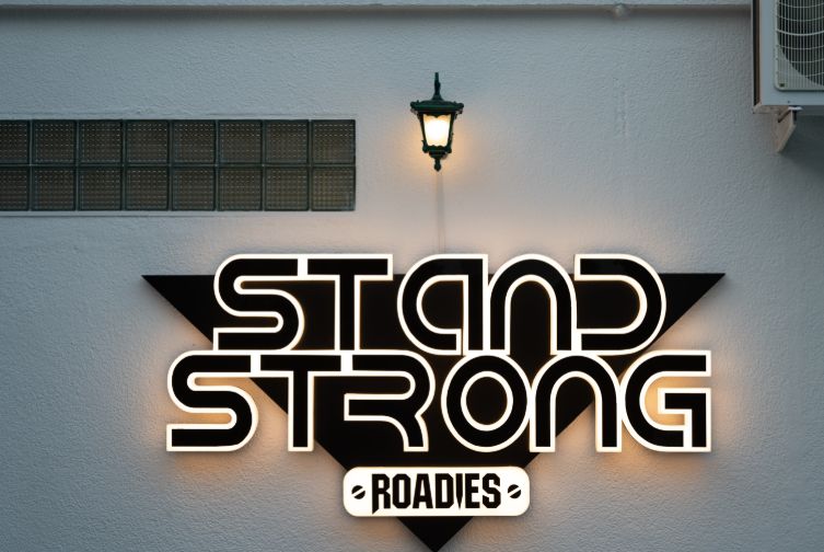 Close-up of the Stand Strong Roadies signage mounted on the wall at Roadies Rostel ARC Resort