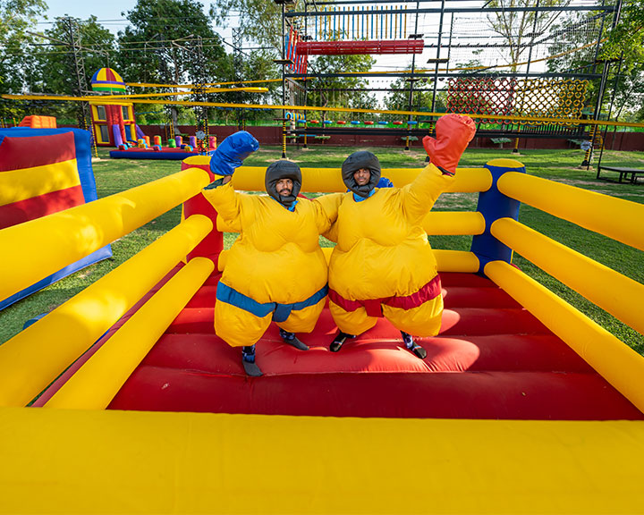 Two guests having fun at the inflatable park area in Roadies Rostel ARC, a top family resort near Ahmedabad