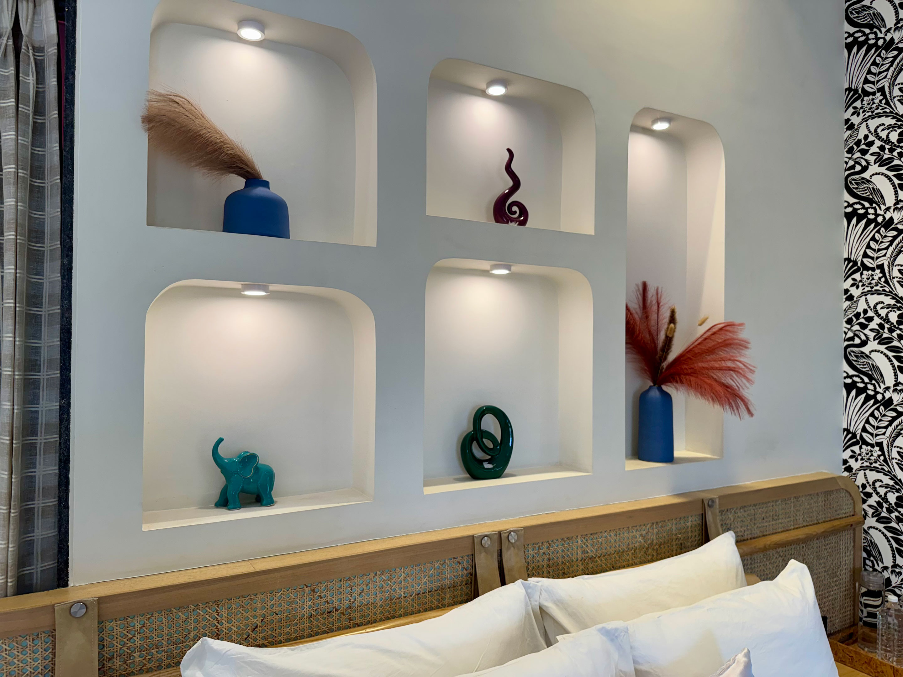Interior design at Roadies Rostel ARC featuring wall niches with subtle lighting and earthy décor for a calming resort feel in Ahmedabad