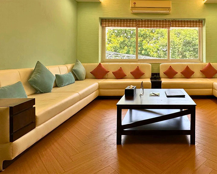 Cozy sitting room with pastel sofas and wooden floors at Roadies Rostel ARC designed for comfort and family gatherings