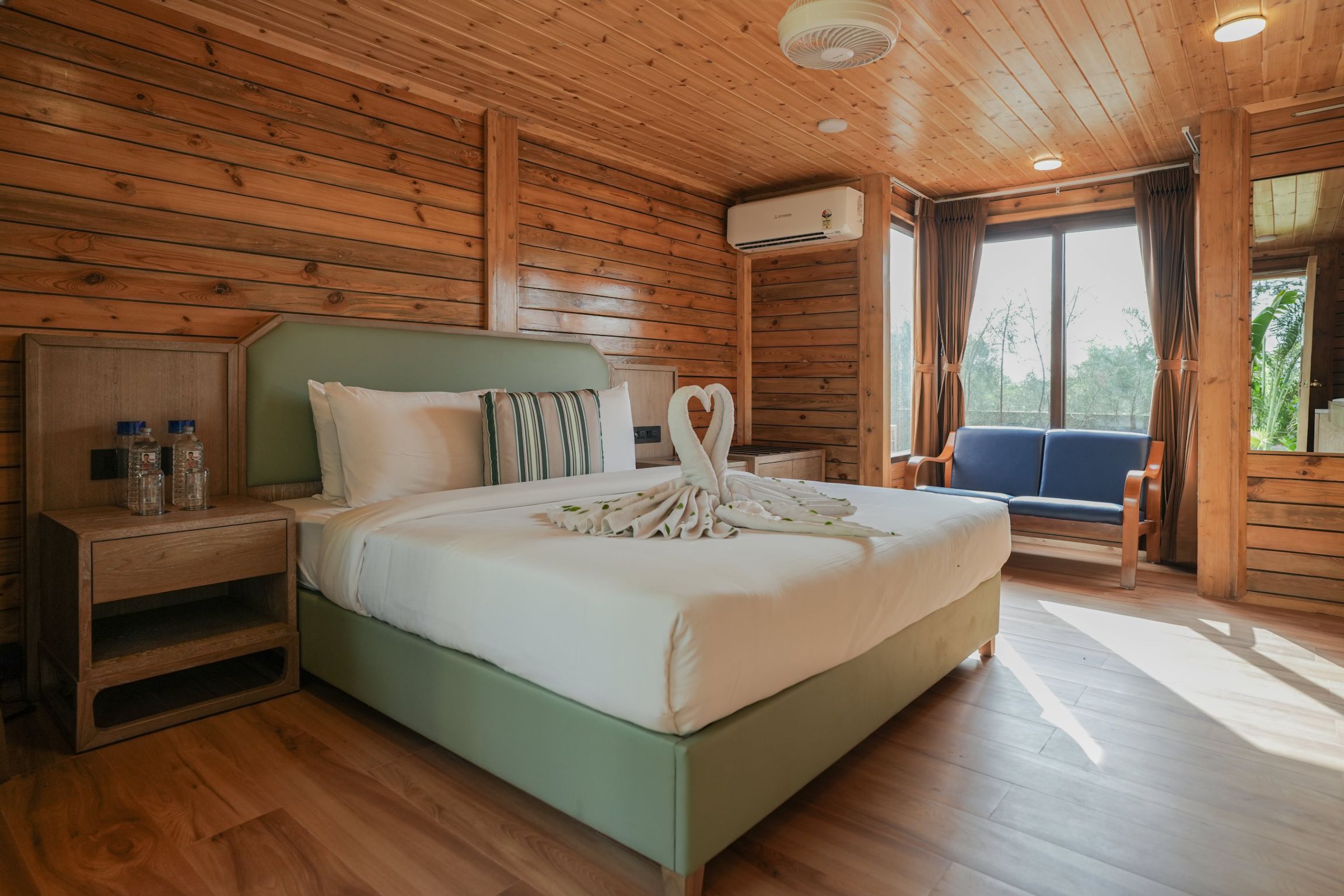 Spacious wooden cottage bedroom with AC and amenities – perfect luxury resort room near Ahmedabad