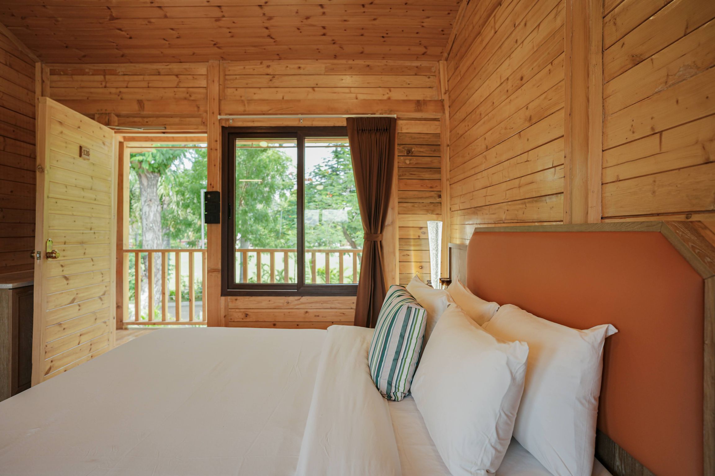 Double bed cottage room with wooden interiors and seating – comfortable resort room in nature setting